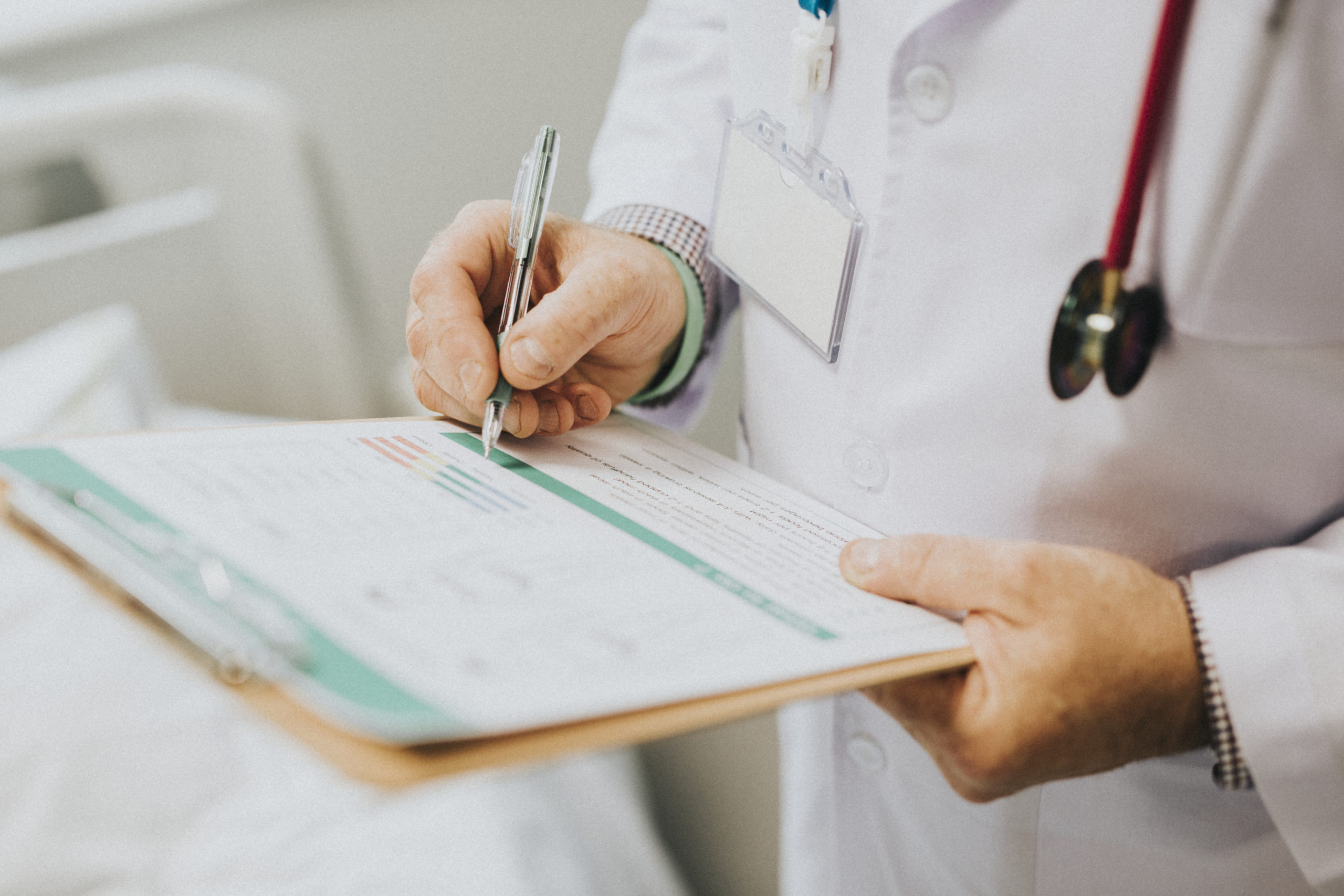 Physician noting down symptoms of a patient Physician noting down symptoms of a patient